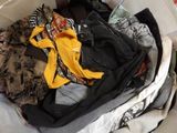 a pile of clothes in a suitcase on the floor