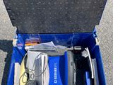 a blue tool box with tools in it sitting on the ground