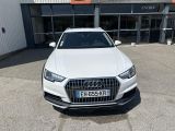 a white audi suv parked in front of a building