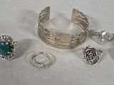 several different rings and bracelets sitting on a white surface