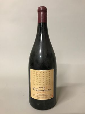 a bottle of wine sitting on top of a table next to a bottle of wine