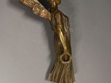 bronze statue of a woman holding a vase on a gray wall