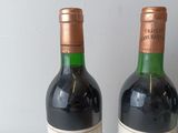 two bottles of wine sitting on a table next to each other