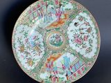 an ornately decorated plate with flowers and birds on a black background