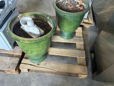 deux jardinières vertes posées sur une palette à côté d'un poêle