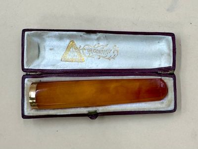 an orange comb in a purple case on a white table