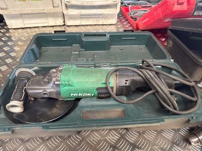 a green box with a tool in it on the floor