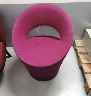 a pink chair and a red chair in a room