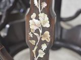 a close up of a wooden chair with a floral design on it