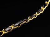 a close up of a gold chain on a black background