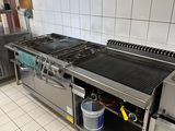 a kitchen with a stove, sink, and refrigerator in it