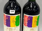 two bottles of red wine sitting next to each other on a table