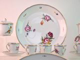 a white table topped with plates and cups and saucers