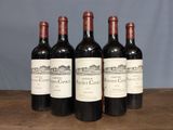four bottles of red wine are lined up on a table