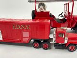 a red toy truck with a red caboose on the back of it