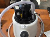 un aspirateur posé sur une table, muni d'un tuyau