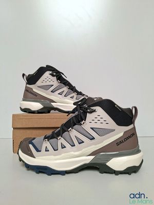 un gros plan sur une paire de chaussures de randonnée posées sur une boîte