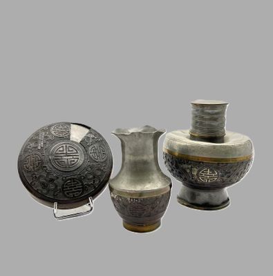 trois vases posés l'un à côté de l'autre sur une table