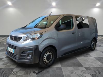une camionnette argentée garée dans une pièce au sol en damier