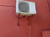 un petit climatiseur fixé sur le mur latéral d'un immeuble