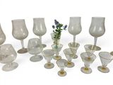 a lot of wine glasses and vases on the table
