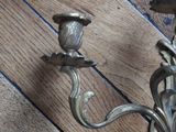 two candles that are on the wall on the wooden floor