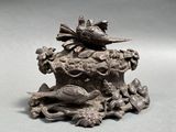 a statue of a bird sitting on top of a tree stump