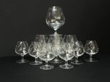 Plusieurs verres à vin vides sont disposés en pyramide sur une surface noire