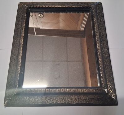 un miroir accroché au mur au-dessus d'un sol carrelé
