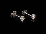 une paire de boucles d'oreilles en argent sur fond noir