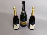 trois bouteilles de champagne posées côte à côte sur une table
