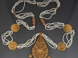 an image of a necklace with coins and a pendant on a table