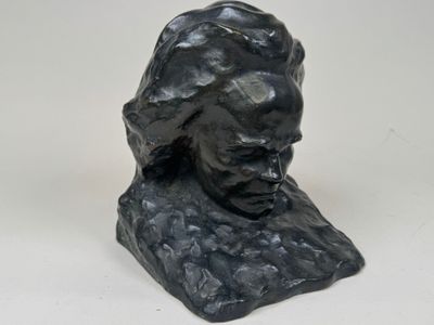 un gros plan sur la tête d'un homme sculptée sur une surface blanche