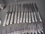 a lot of silverware on a table with a spoon and knife