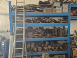 a blue shelving filled with assorted items in a garage