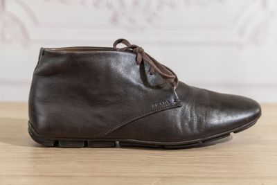 des bottines en cuir marron à lacets posées sur une table en bois