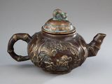 a brown teapot with a bird on it