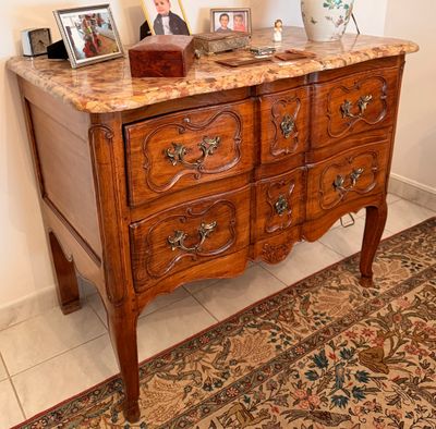 une commode avec un plateau en marbre dans une pièce