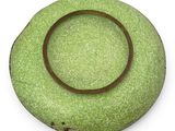 a green bowl with a brown rim sitting on a white surface