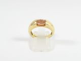 a yellow gold ring with an oval stone in the center