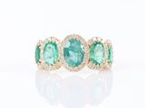 une bague sertie de trois pierres d’émeraude et de diamants