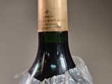 a bottle of wine wrapped in plastic on a table