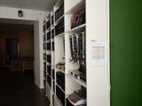 a green wall in a room with white shelvings