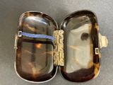 a tortoise shell case with a blue ribbon in it