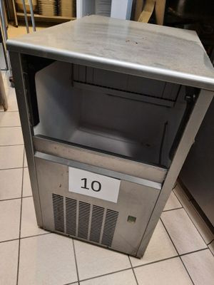 une petite machine à glaçons posée par terre dans la cuisine