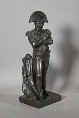 bronze statue of a man with a hat on his head holding a dog