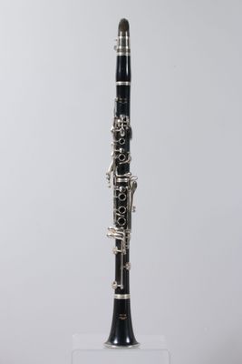 a close up of a black and silver clarinet on a clear stand