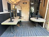 two tables and a bench on the porch of a building