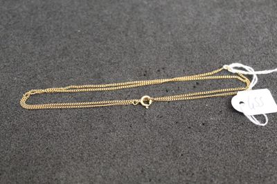 a gold necklace with a tag on it sitting on a table