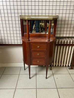 une petite armoire en bois surmontée d'un miroir